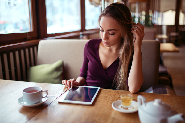 A woman who uses a tablet computer in a coffee shop Stock Photo 02