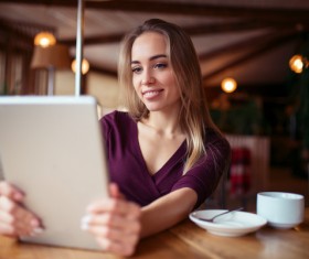 A woman who uses a tablet computer in a coffee shop Stock Photo 03