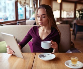 A woman who uses a tablet computer in a coffee shop Stock Photo 04
