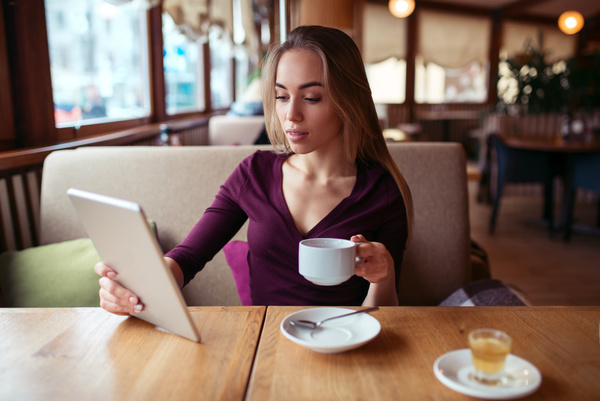 A woman who uses a tablet computer in a coffee shop Stock Photo 04