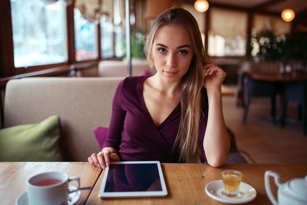 A woman who uses a tablet computer in a coffee shop Stock Photo 05