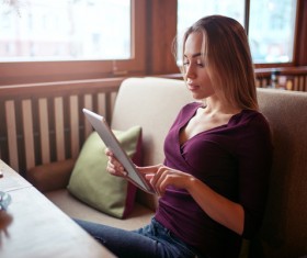 A woman who uses a tablet computer in a coffee shop Stock Photo 06