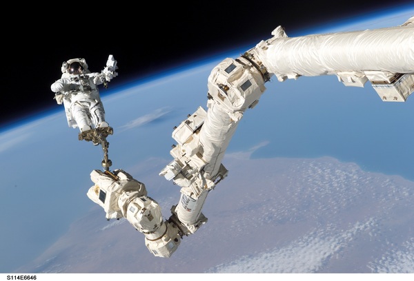 Astronauts on the robotic arm Stock Photo