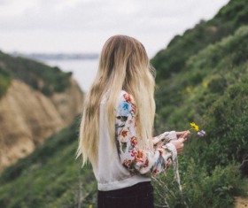 Blonde girl enjoying fresh air on mountain Stock Photo