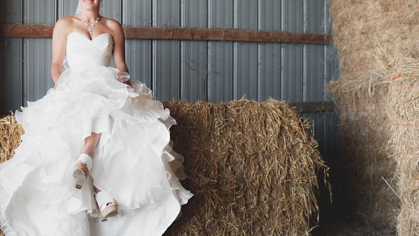 Bride posing with white dress in straw storehouse Stock Photo