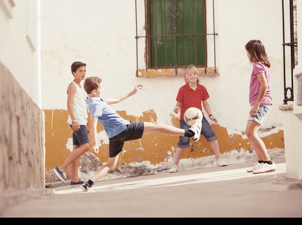 Children playing football in the alley Stock Photo
