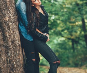 Couple leaning against trees Stock Photo