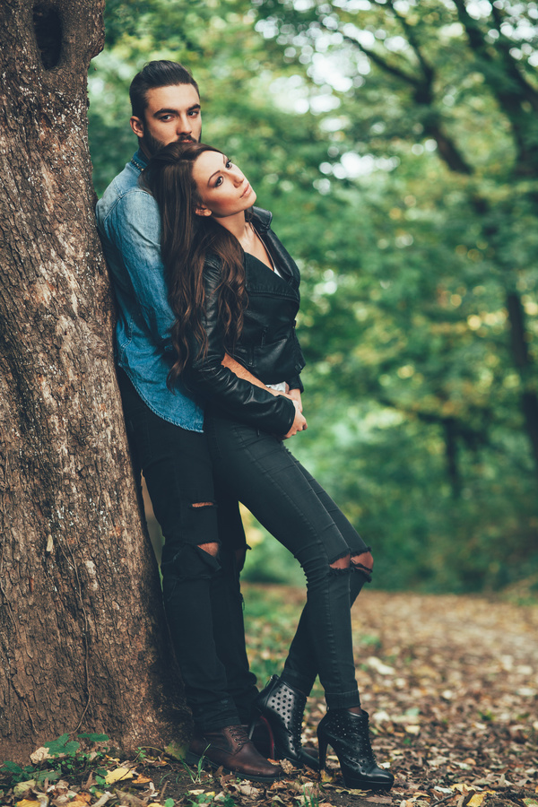 Couple leaning against trees Stock Photo