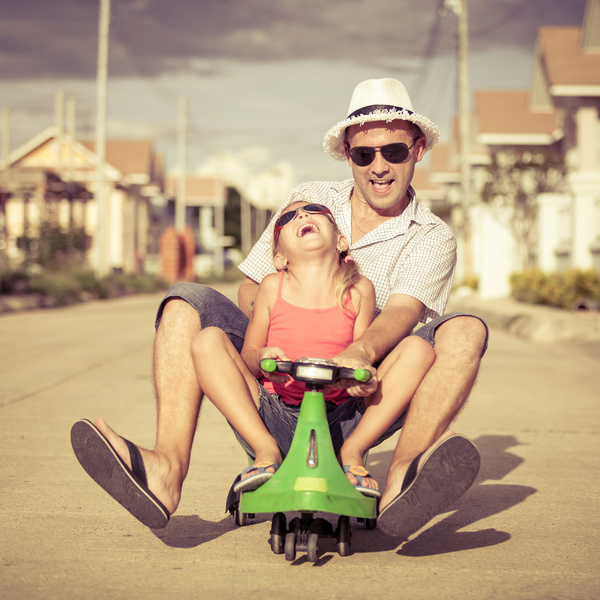 Dad and little girl driving electric toy car Stock Photo