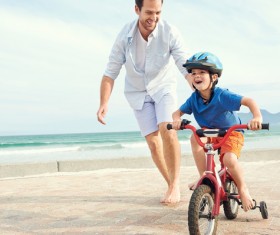 Guarding her son riding a bike Stock Photo