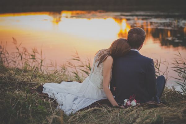 Intimate couple sitting by the river Stock Photo