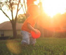 Little boy playing with ball under sunlight Stock Photo