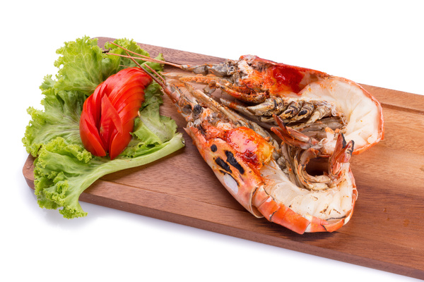 Lobster on the chopping board with vegetables and tomatoes Stock Photo