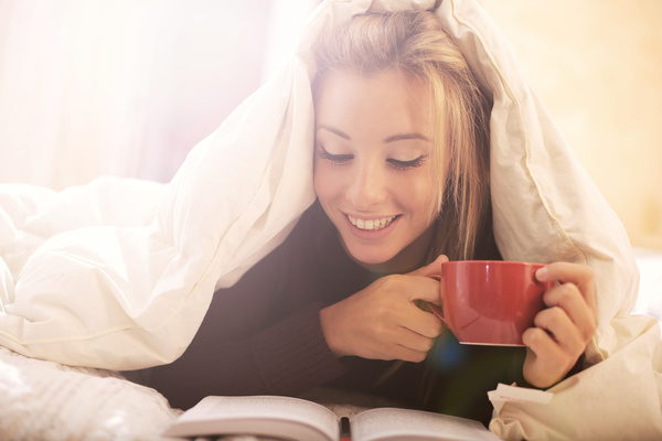 Lying in bed drinking coffee reading girl Stock Photo 01