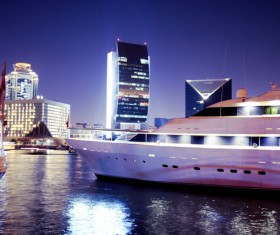 Moored yacht with a brightly lit city Stock Photo