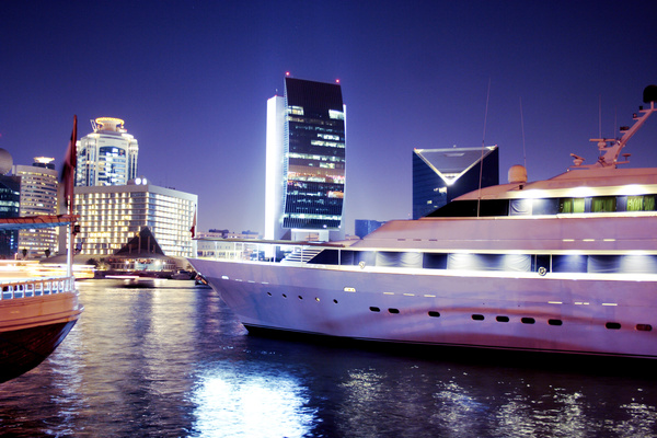 Moored yacht with a brightly lit city Stock Photo