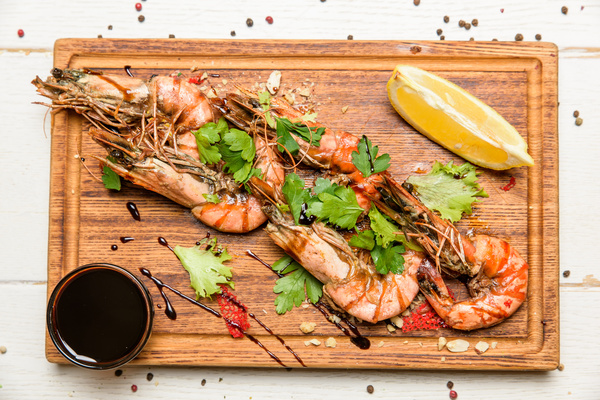Prawns with sauce on the chopping block Stock Photo