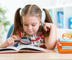 Pre-school children who read books with magnifying glass Stock Photo