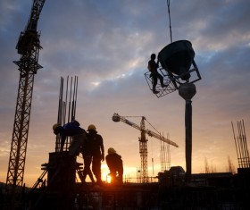 Sunset busy construction workers Stock Photo