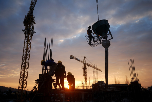 Sunset busy construction workers Stock Photo