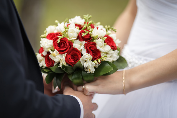 The bride and groom hold the bouquet Stock Photo