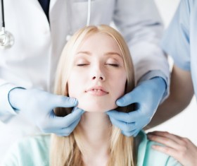 The doctor checks the patients tonsils Stock Photo