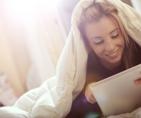 The girl lying on the bed reading Stock Photo 03