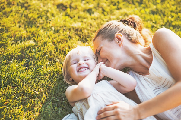 The mother and daughter lying on the grass Stock Photo