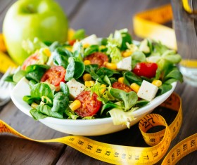Vegetable salad and tape measure on the table Stock Photo