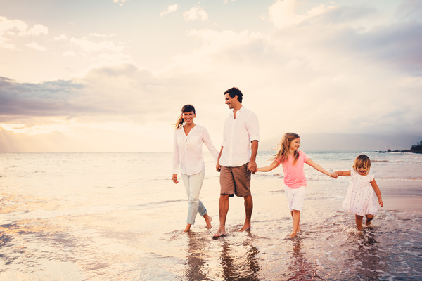 Walking on the beach a happy family of four Stock Photo