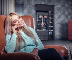 Woman sitting on the couch to call Stock Photo