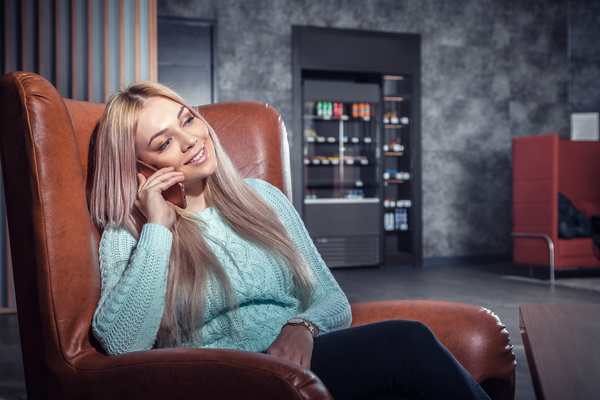 Woman sitting on the couch to call Stock Photo