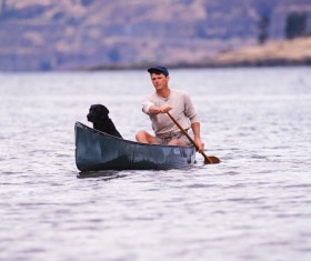 A man and a dog with a boat Stock Photo