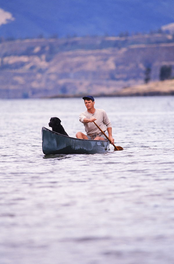 A man and a dog with a boat Stock Photo