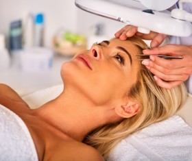 Beautician trims eyebrows for customers Stock Photo 01