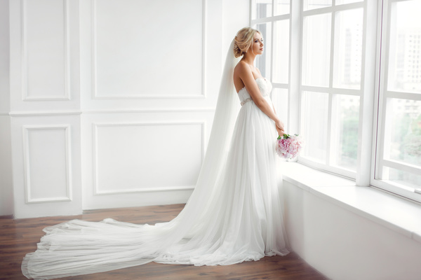 Beautiful bride standing at the window Stock Photo
