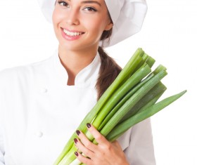 Beautiful female chef holding a green onions Stock Photo