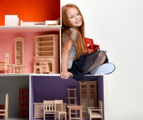 Happy little girl playing doll house filled with mini furniture toys Stock Photo 01