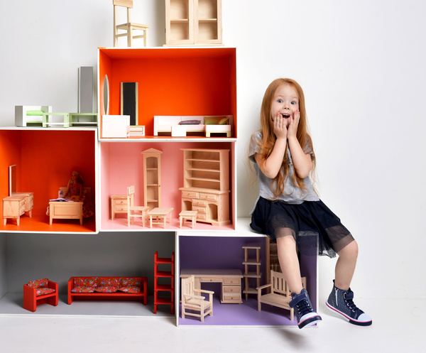 Happy little girl playing doll house filled with mini furniture toys Stock Photo 02