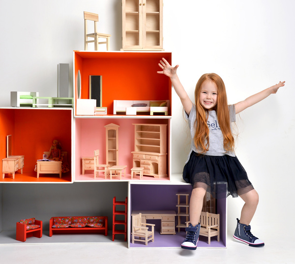 Happy little girl playing doll house filled with mini furniture toys Stock Photo 03