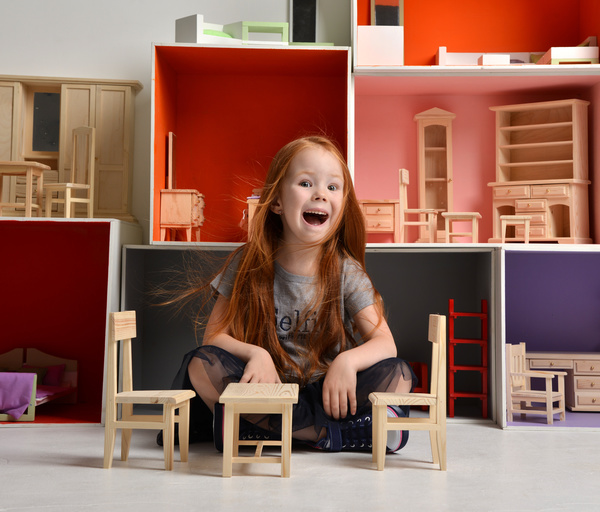 Happy little girl playing doll house filled with mini furniture toys Stock Photo 07