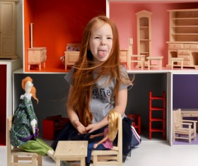 Happy little girl playing doll house filled with mini furniture toys Stock Photo 10
