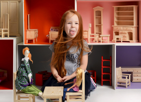 Happy little girl playing doll house filled with mini furniture toys Stock Photo 10