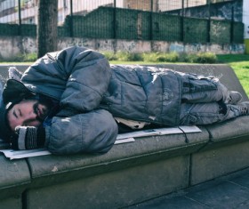 Lying on the bench to sleep on the beggar Stock Photo