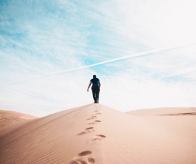 Man walking alone on dune Stock Photo