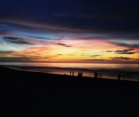 People on seascape at dusk Stock Photo
