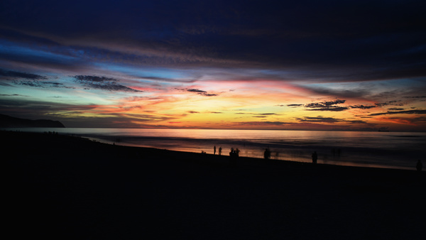 People on seascape at dusk Stock Photo