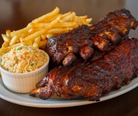 Plate of bacon with fries and vegetables Stock Photo