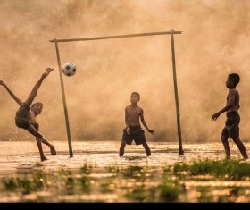 The children who play football in the water Stock Photo