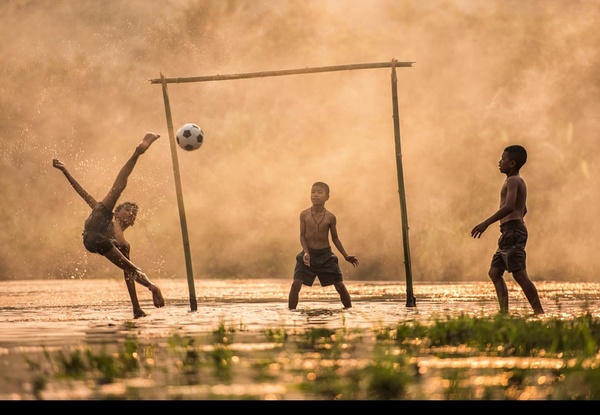 The children who play football in the water Stock Photo